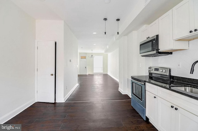 kitchen featuring baseboards, white cabinets, dark wood-style floors, stainless steel appliances, and a sink