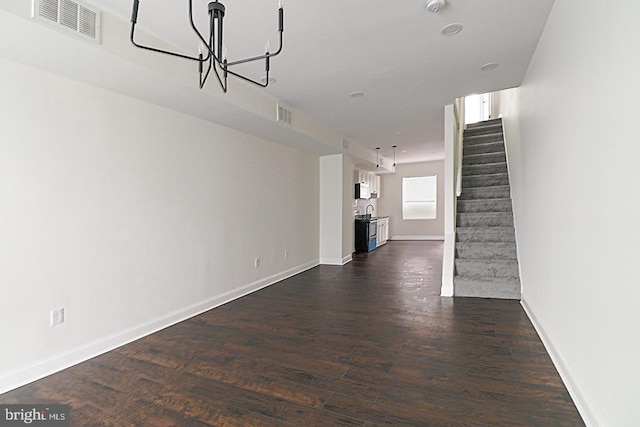 unfurnished living room with baseboards, stairs, visible vents, and dark wood finished floors