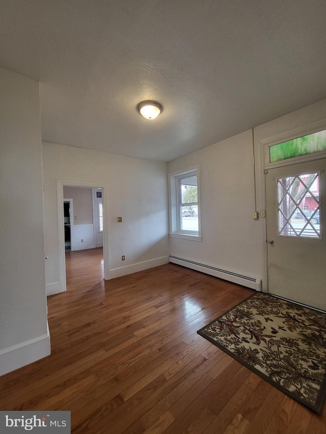 entrance foyer featuring hardwood / wood-style flooring, baseboards, and baseboard heating