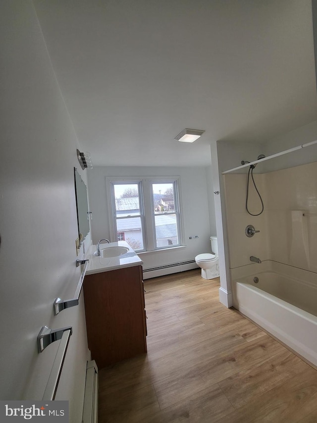 bathroom featuring toilet, baseboard heating, a baseboard heating unit, vanity, and wood finished floors