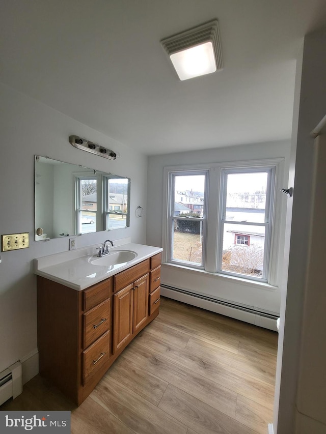 bathroom featuring a baseboard radiator, wood finished floors, and vanity