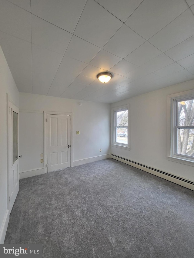 carpeted spare room featuring a baseboard radiator and baseboards