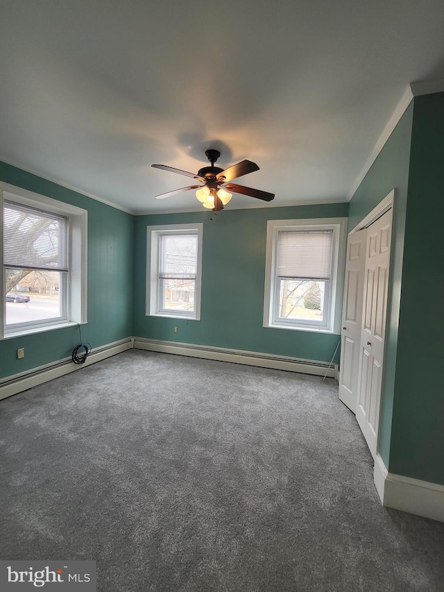 spare room featuring carpet, crown molding, baseboards, and ceiling fan