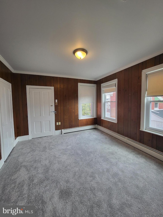 spare room featuring a baseboard radiator, crown molding, and carpet flooring