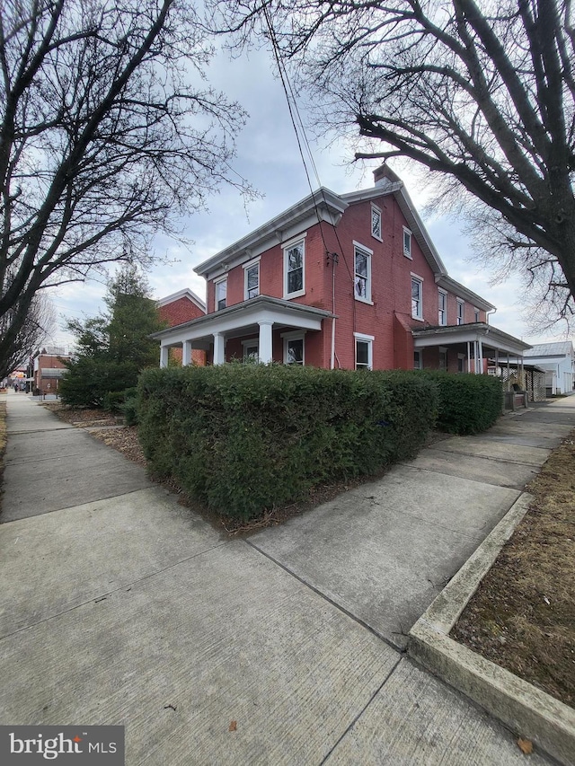 view of property exterior featuring brick siding and a chimney