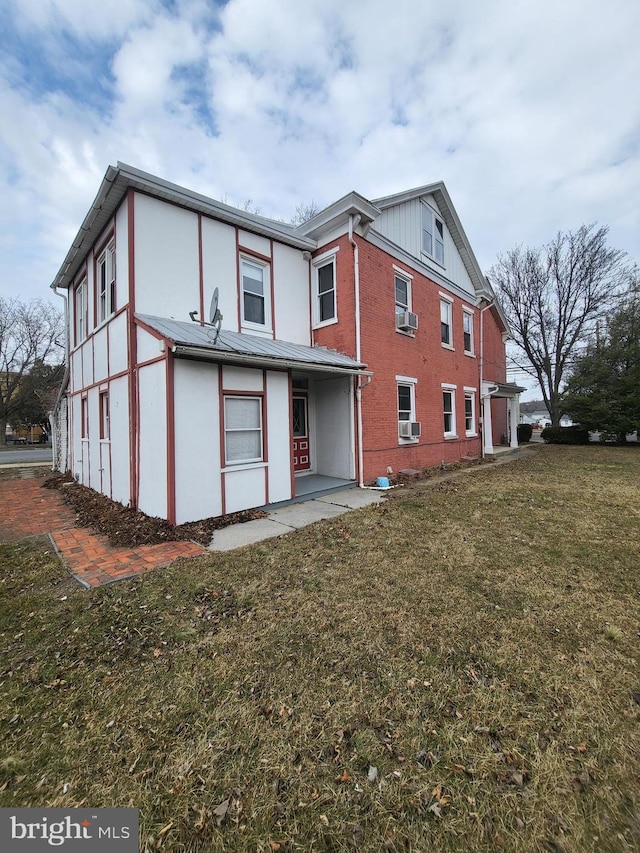 rear view of property featuring cooling unit and a lawn