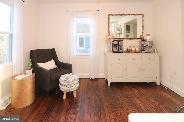 sitting room with dark wood-type flooring and baseboards