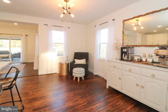 living area with a chandelier, recessed lighting, dark wood-type flooring, and baseboards