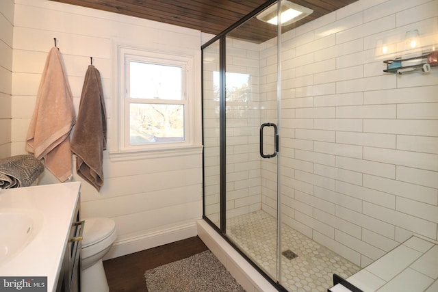 full bathroom featuring a stall shower, vanity, and wood finished floors