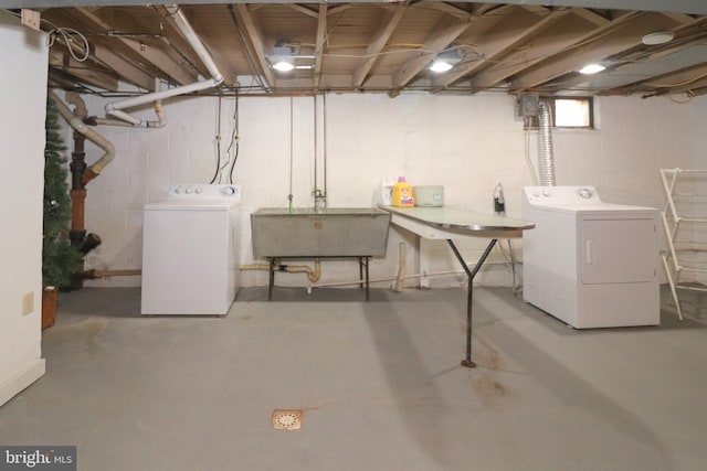 basement featuring independent washer and dryer and a sink