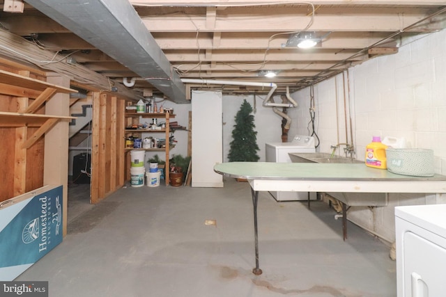 unfinished basement with concrete block wall and washer and dryer