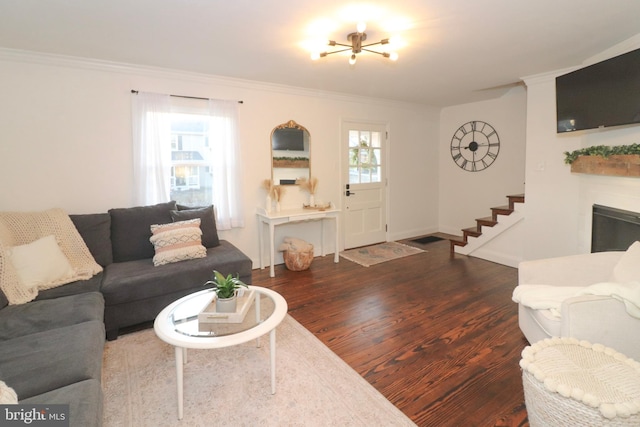 living room with a healthy amount of sunlight, dark wood-style floors, and ornamental molding