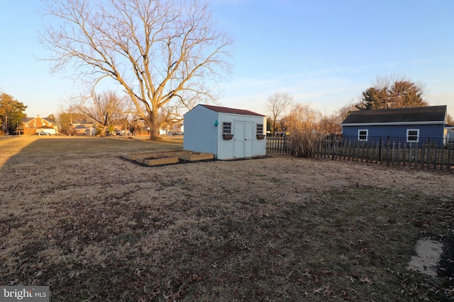 view of yard featuring a storage shed, an outdoor structure, and fence