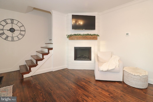 unfurnished living room with crown molding, stairs, a fireplace, and wood finished floors