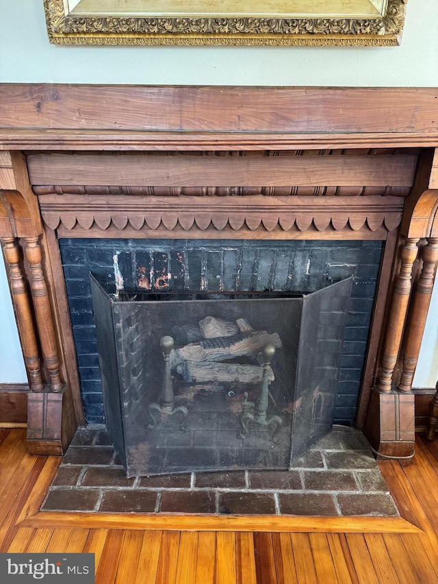 details featuring a fireplace with flush hearth and wood finished floors