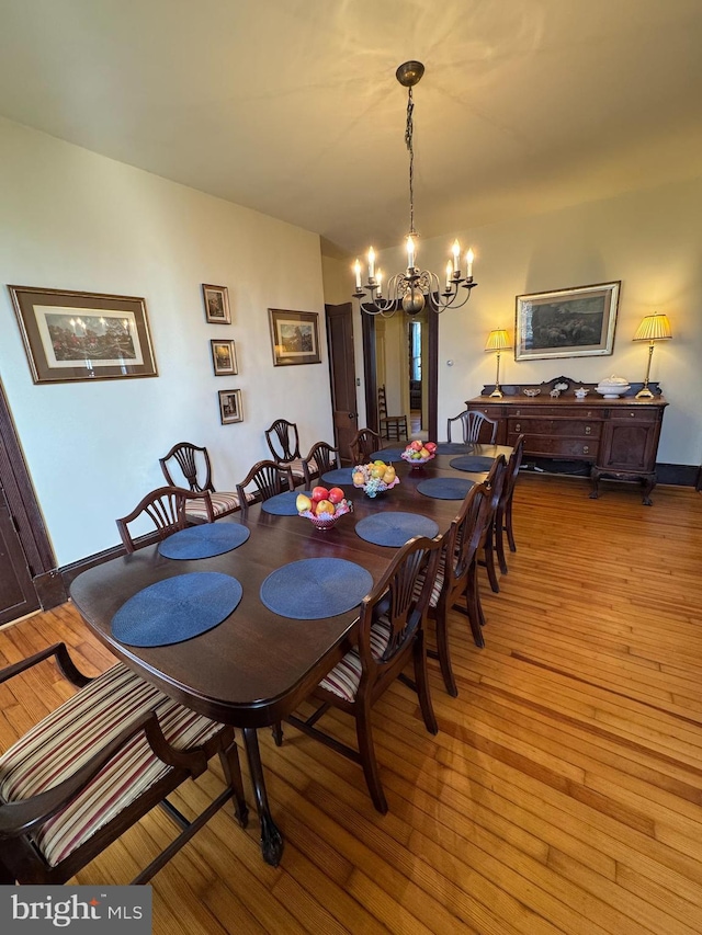 dining space featuring light wood finished floors and a notable chandelier