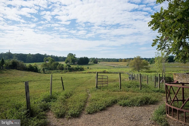 view of yard with a rural view and fence