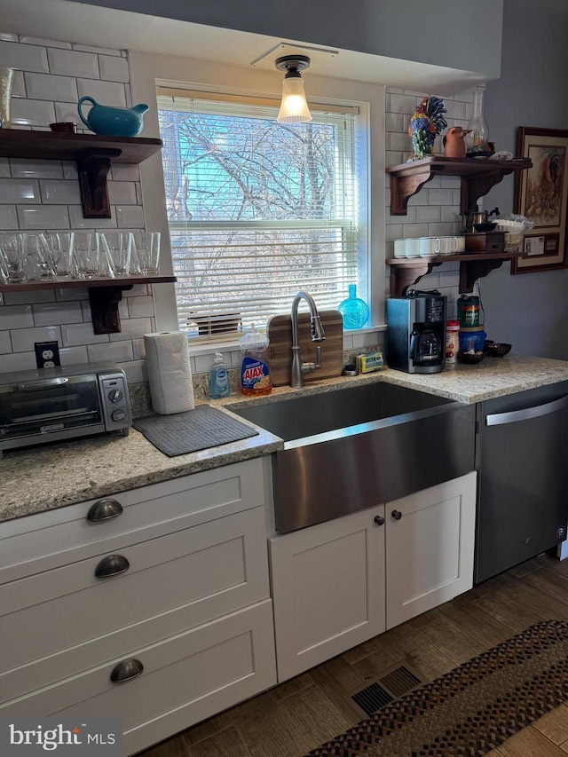 kitchen featuring a toaster, a sink, stainless steel dishwasher, decorative backsplash, and open shelves