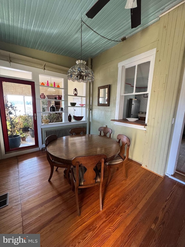 dining room with radiator, visible vents, and wood finished floors