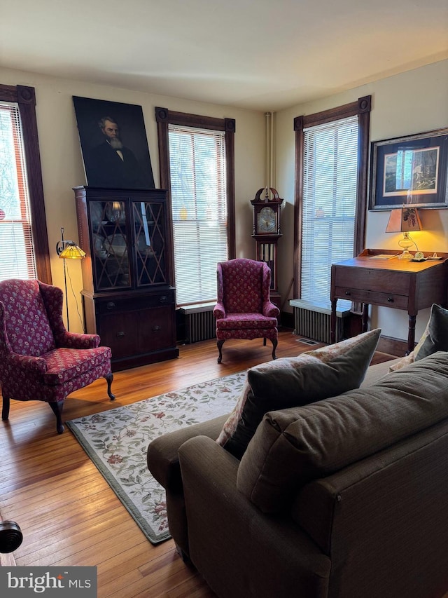 living area featuring radiator and hardwood / wood-style floors