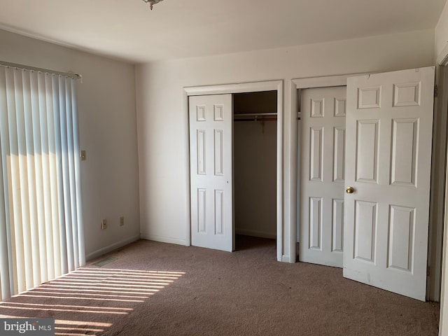 unfurnished bedroom with carpet floors and baseboards