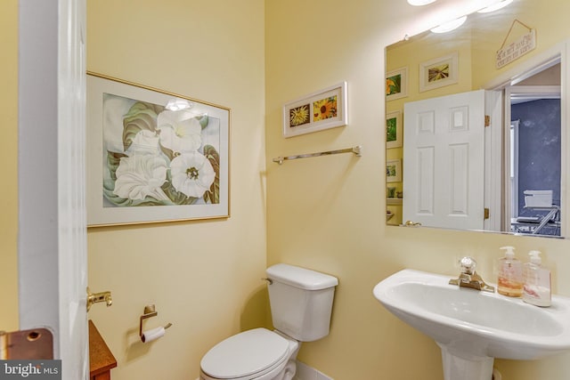 half bath featuring toilet and a sink