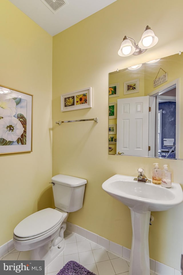 half bath featuring tile patterned flooring, toilet, baseboards, and visible vents