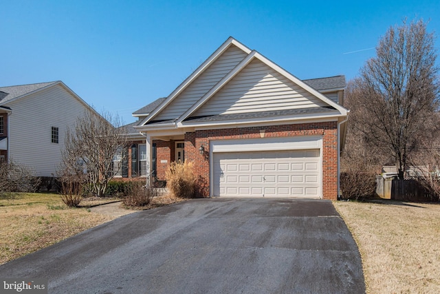 view of front of home featuring driveway, a shingled roof, a front yard, an attached garage, and brick siding