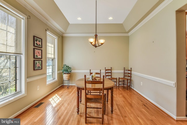 dining room with baseboards, visible vents, an inviting chandelier, light wood-style flooring, and ornamental molding