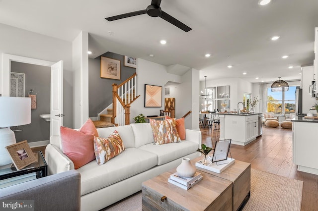 living area with ceiling fan, stairs, hardwood / wood-style floors, and recessed lighting