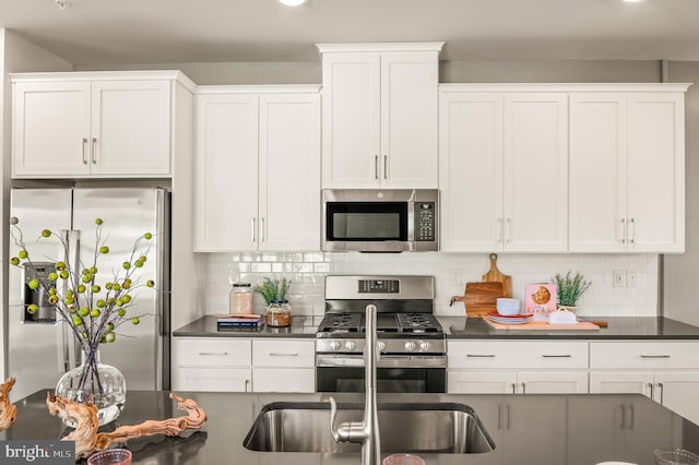 kitchen with appliances with stainless steel finishes, dark countertops, and decorative backsplash