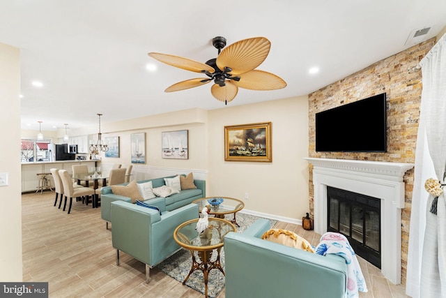 living room featuring recessed lighting, ceiling fan, visible vents, and a glass covered fireplace