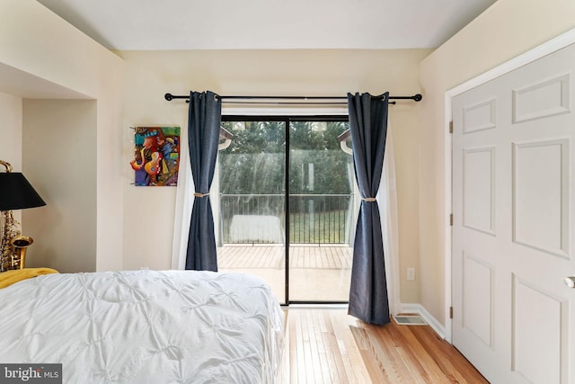 bedroom with access to outside, baseboards, and wood finished floors