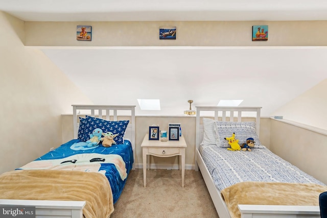 carpeted bedroom featuring a skylight and baseboards