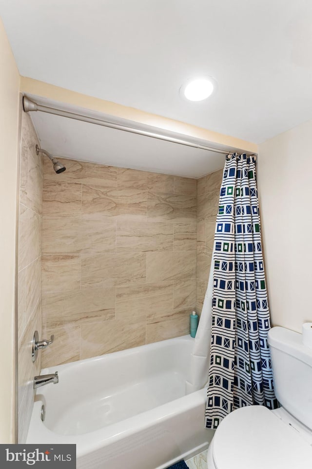 bathroom with toilet and shower / bath combo with shower curtain