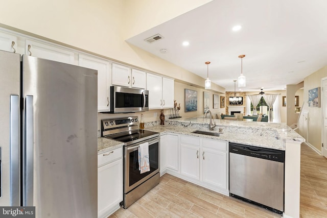 kitchen featuring stainless steel appliances, visible vents, white cabinetry, a sink, and a peninsula