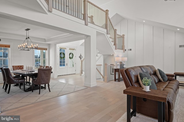 dining space featuring visible vents, stairway, french doors, light wood finished floors, and a raised ceiling