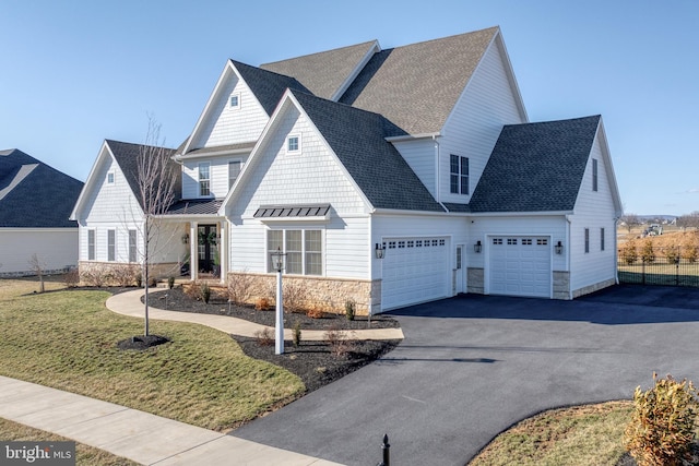 view of front of property with fence, aphalt driveway, metal roof, a garage, and a standing seam roof