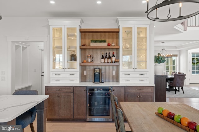 bar with recessed lighting, wine cooler, pendant lighting, a notable chandelier, and light wood-type flooring