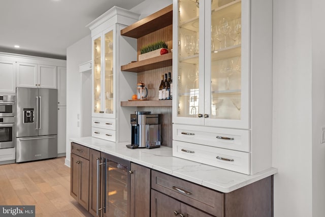 kitchen with light wood-type flooring, open shelves, stainless steel appliances, wine cooler, and white cabinets