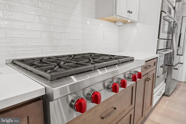 kitchen featuring light stone countertops, tasteful backsplash, and designer range