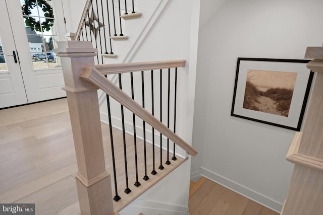 staircase with baseboards and wood finished floors