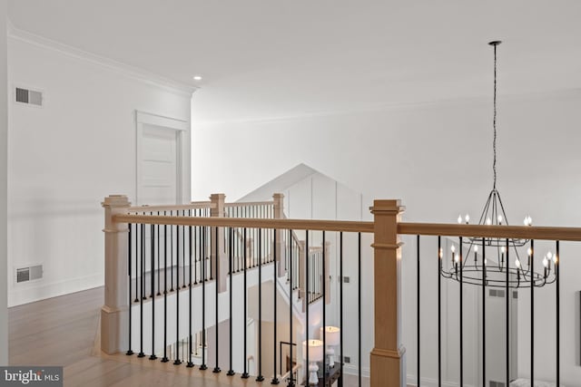 interior space featuring visible vents, wood finished floors, baseboards, and ornamental molding