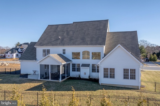 back of house with a lawn, roof with shingles, a fenced backyard, and a sunroom