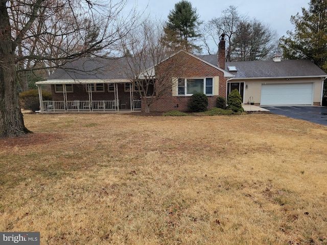 single story home featuring an attached garage, driveway, a porch, and a front yard