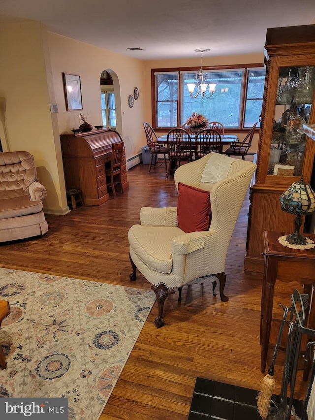 living area featuring visible vents, arched walkways, a baseboard radiator, wood finished floors, and a chandelier