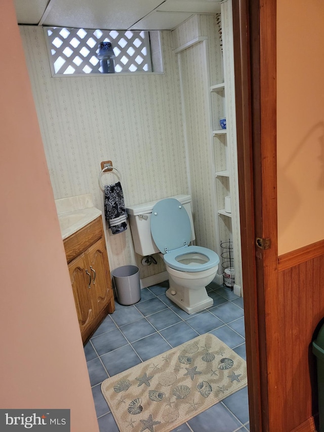 bathroom with toilet, tile patterned flooring, and vanity