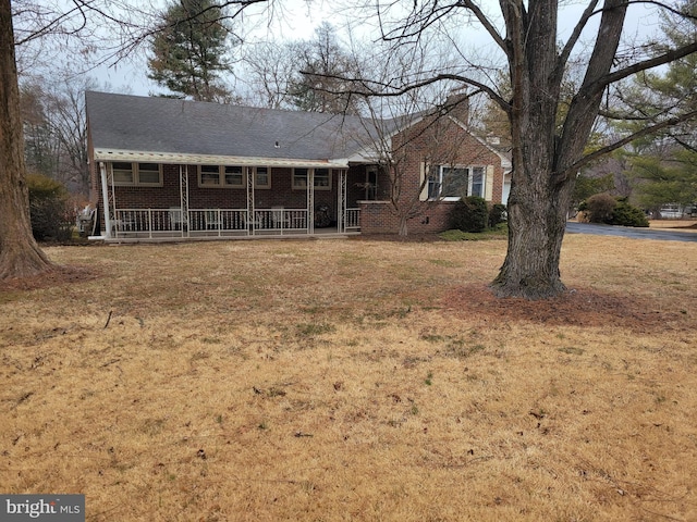 single story home with a front yard, a porch, and brick siding