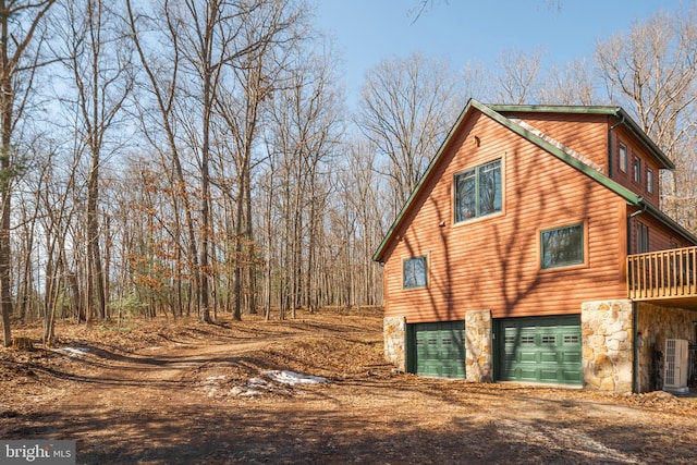 view of home's exterior with driveway, stone siding, cooling unit, and log veneer siding