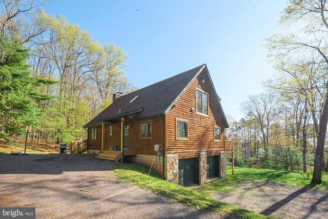 view of property exterior featuring a garage, driveway, and a chimney